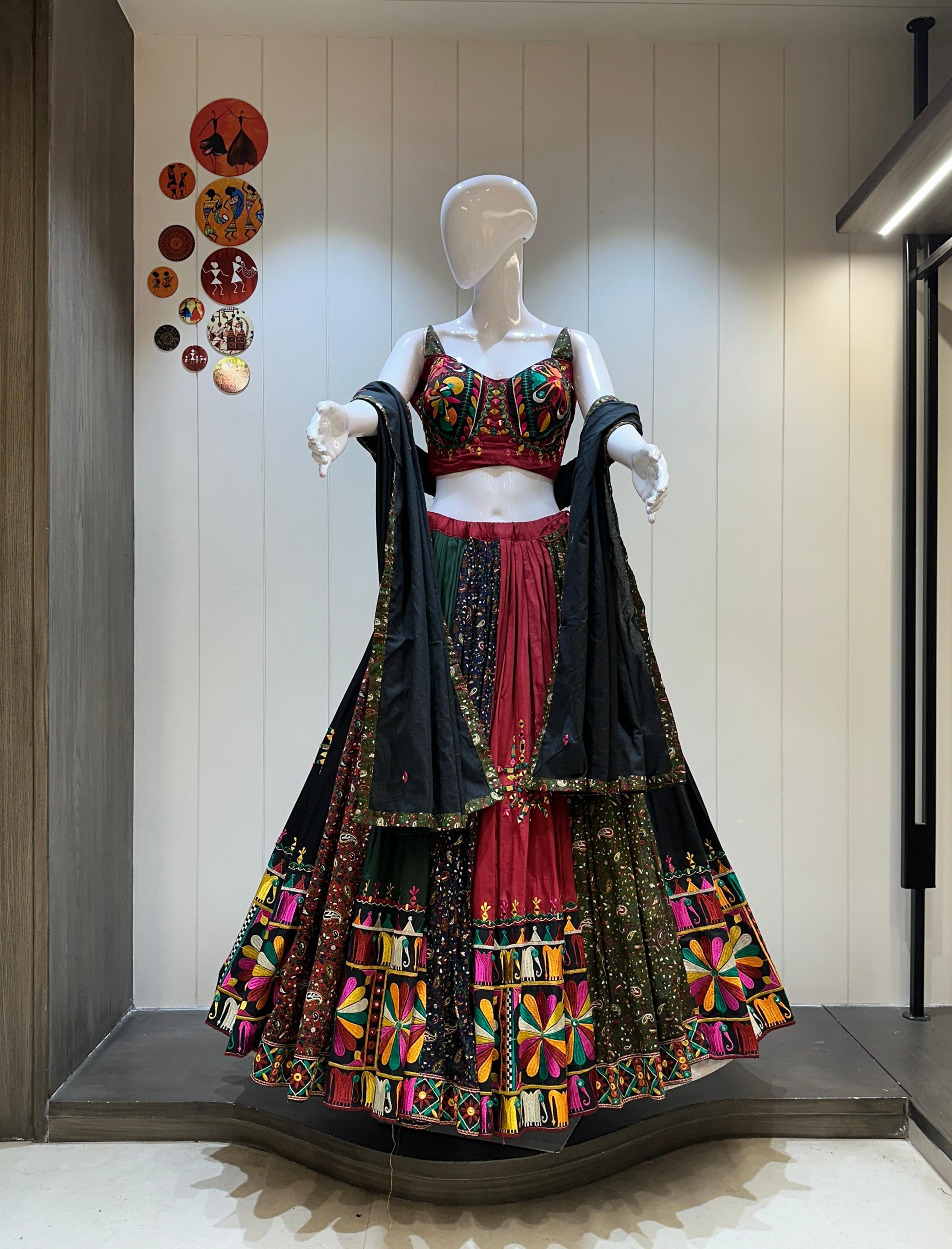 Colorful traditional outfit on a mannequin against a neutral wall.